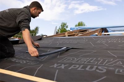 Personne installant des équipements de la marque DELTA® pour sa toiture.